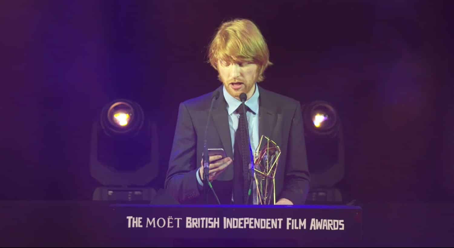 El actor irlandés Domnhall Gleeson durante la ceremonia de los BIFA 2015, aceptando el Premio en nombre de su papá, el también actor Brendan Gleeson.